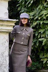 a lady wears a grey crop jacket and midi skirt